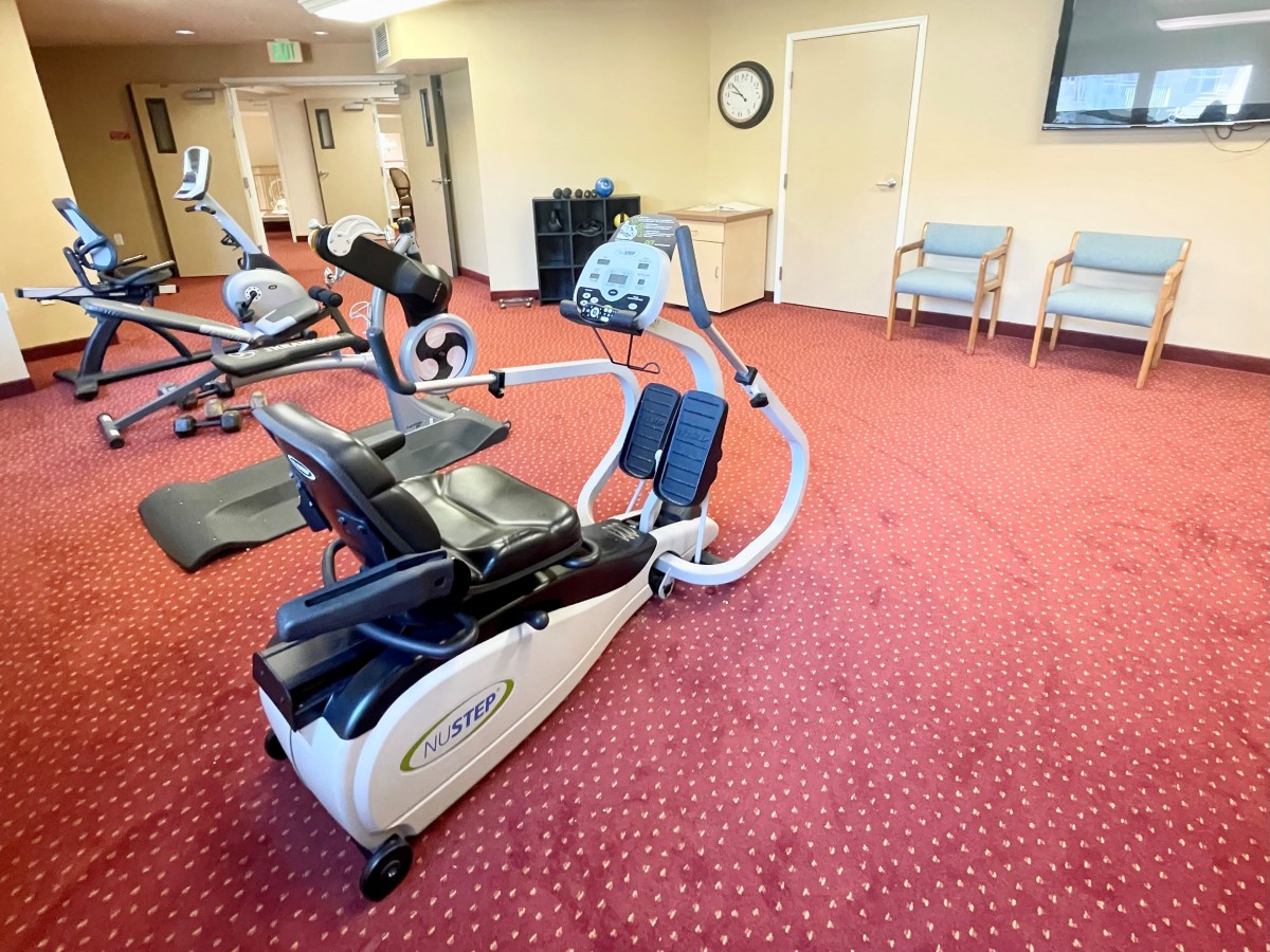 A spacious gym room with exercise machines and cardio equipment.