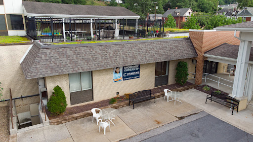 A view of a business building with outdoor seating and clear signage.