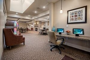 A spacious and well-decorated lobby with a seating area and office space featuring computers.