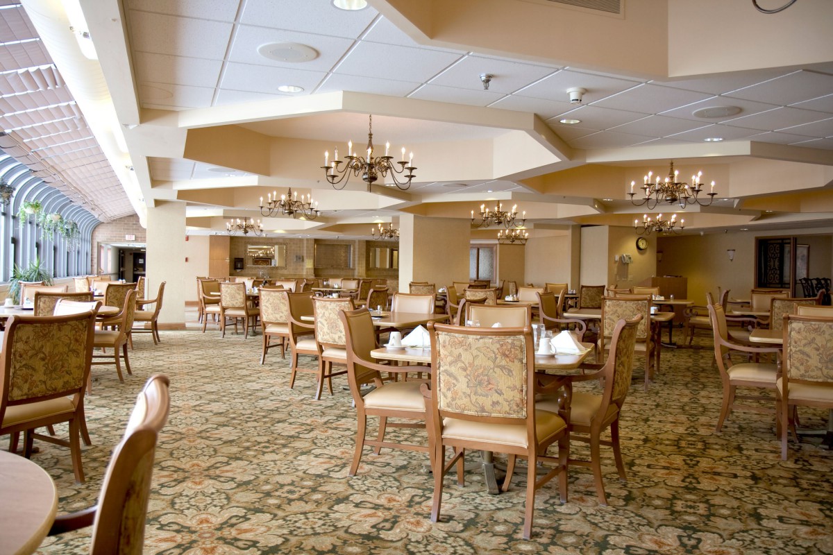 An empty restaurant dining area with neatly arranged tables and chairs.