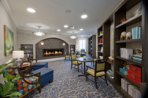 A cozy lounge area featuring a fireplace, comfortable seating, and bookshelves, perfect for relaxation.