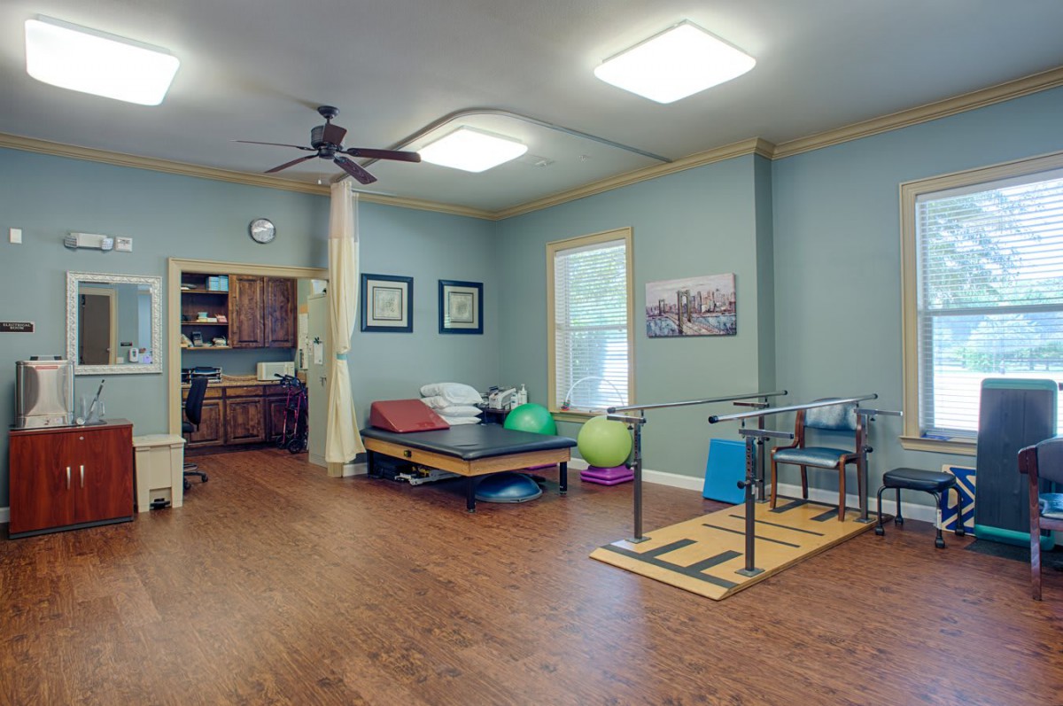 A well-equipped physical therapy room, featuring exercise equipment and a comfortable setup for rehabilitation exercises.