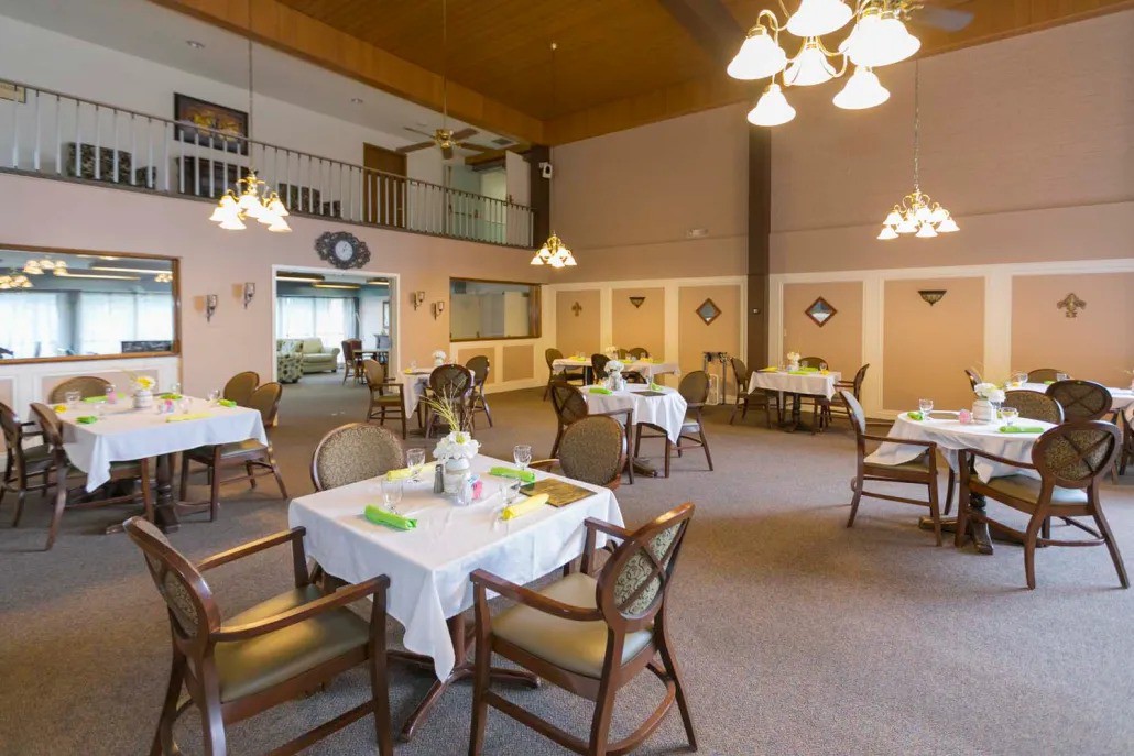A cozy dining room interior with several tables set for a meal.