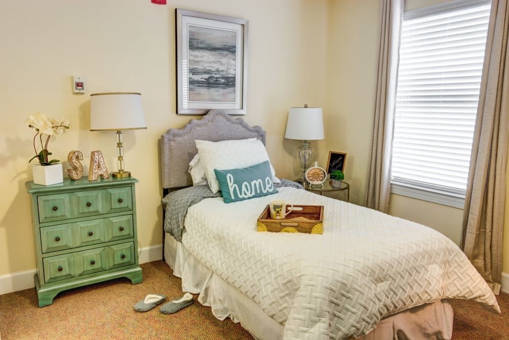 A cozy bedroom with a single bed, nightstand, and decorative elements.