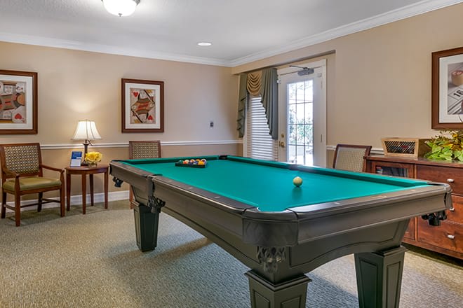A well-lit billiard room featuring a pool table and elegant decor.