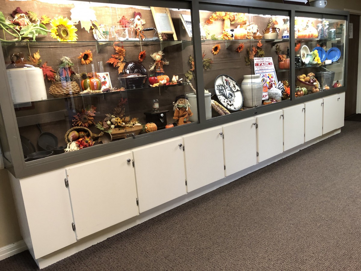 A display case featuring a collection of artifacts and autumn-themed decorations, including sunflowers and various decorative items.