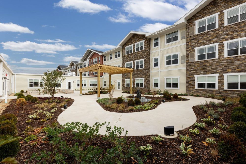A modern residential apartment building with landscaped pathways and gardens.