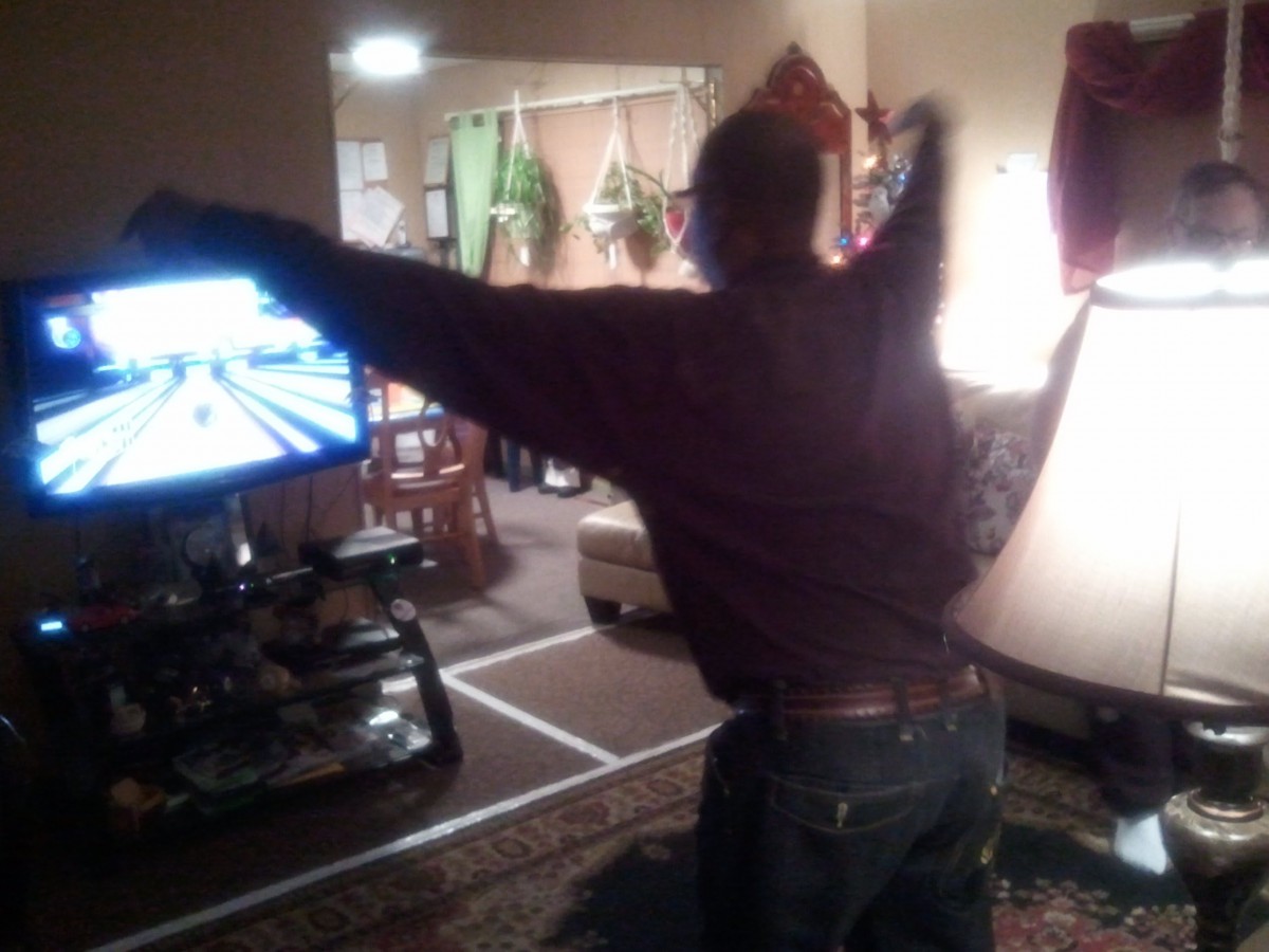 Person playing a bowling game on a video game console in the living room.