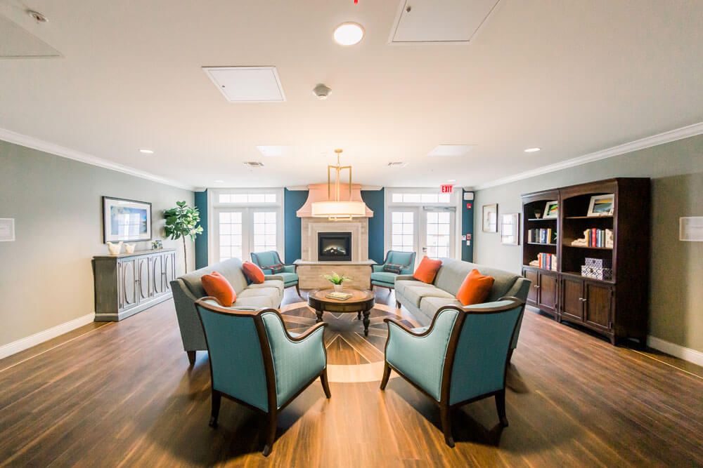 A cozy living room with a central seating area and a fireplace, featuring elegant furniture and modern decor.