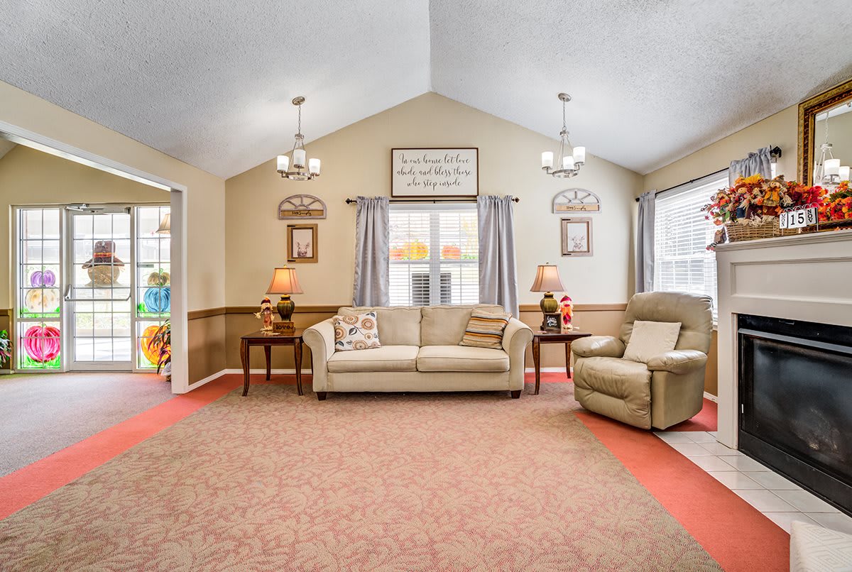 Cozy living room with beige sofa, armchair, and decorative lighting.