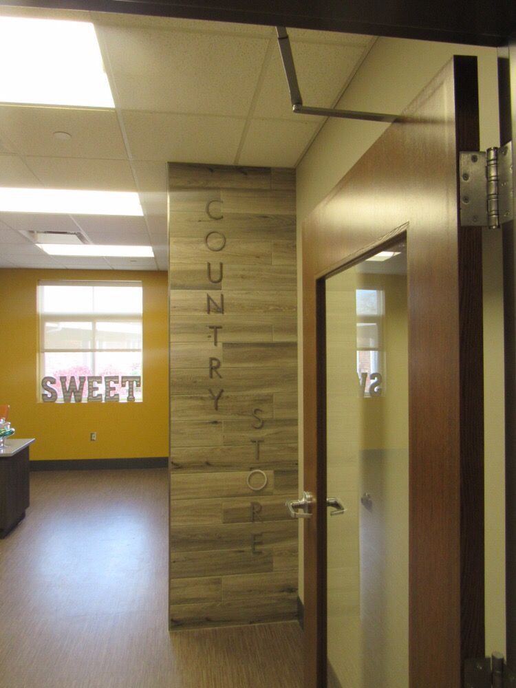 A view of a modern office space featuring a wooden door and bright interior.