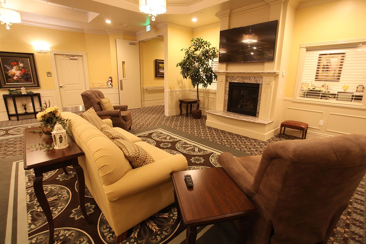 Elegant living room with a cozy seating arrangement, fireplace, and mounted TV.