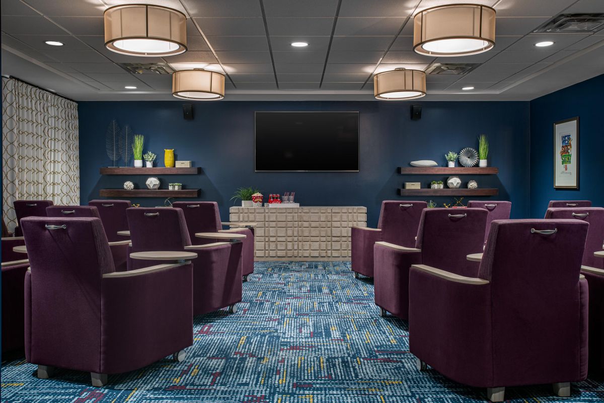 A modern theater room with comfortable seating, stylish decor, and ambient lighting.