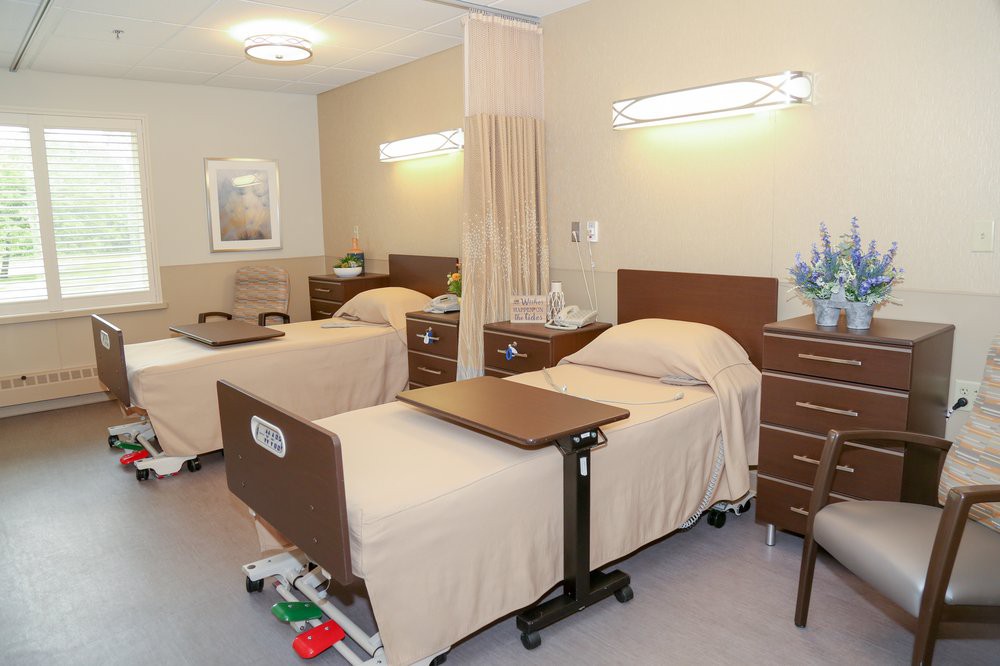 A view of a hospital room with two neatly arranged beds and medical equipment.