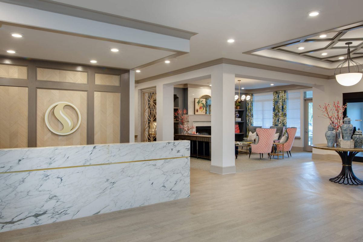 Modern lobby with a marble reception desk and stylish decor.