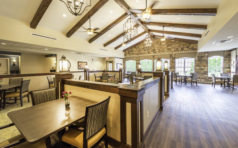 Elegant restaurant interior with wood-beamed ceiling and chandeliers.