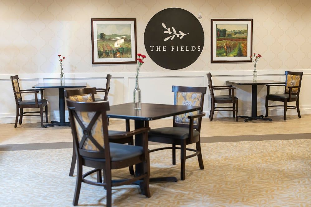 A cozy restaurant interior featuring neatly arranged tables and chairs, with decorative wall art.