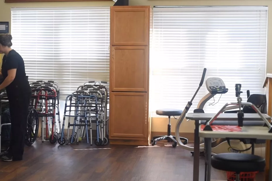 A room with exercise equipment and walkers, likely used for physical therapy.