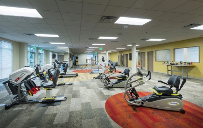 A well-equipped gym featuring various exercise machines and a spacious interior.