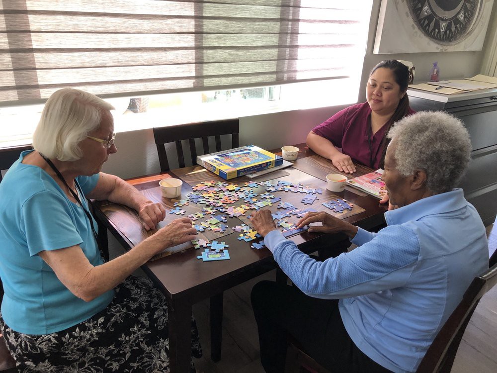 A group of seniors enjoying a puzzle activity together at a table.