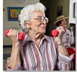 An elderly woman exercising with pink dumbbells, promoting an active and healthy lifestyle.