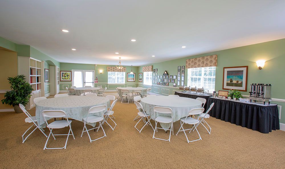 A spacious event room with round tables and chairs arranged for a gathering.
