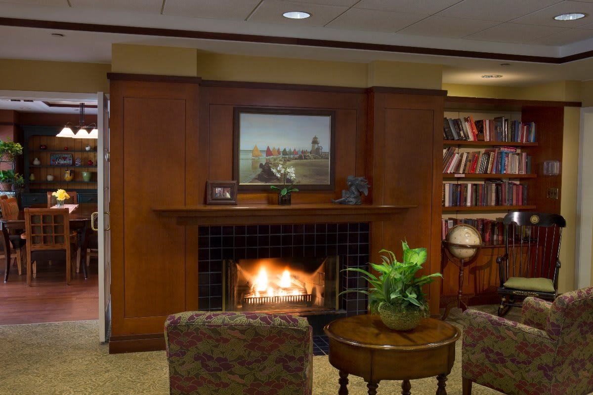 A cozy living room with a fireplace, bookshelves, and comfortable seating.