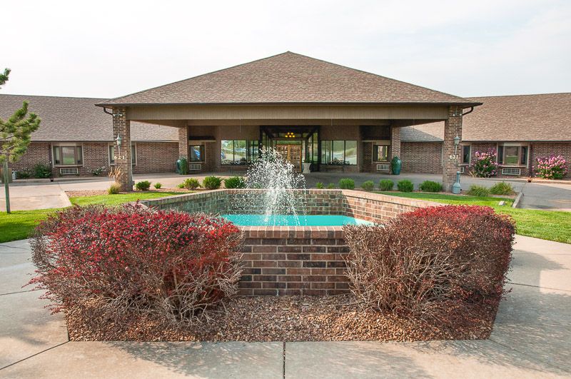 Front view of a building with a central fountain and well-maintained landscaping.