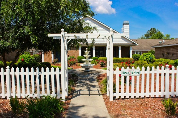 A charming house with a white picket fence and a garden fountain.