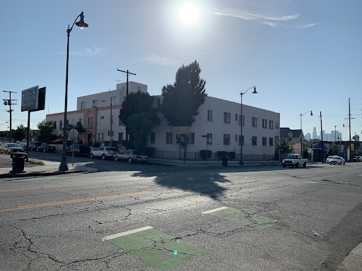 A sunny day in an urban setting, showcasing a building and street scene.