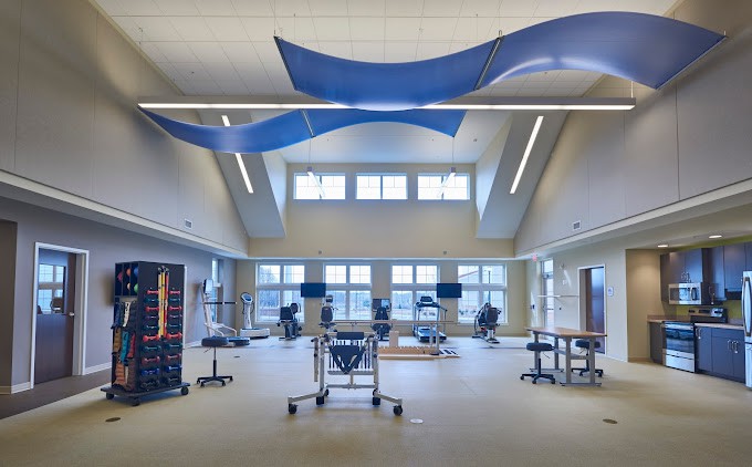 A spacious and modern rehabilitation center equipped with various exercise machines and tools.