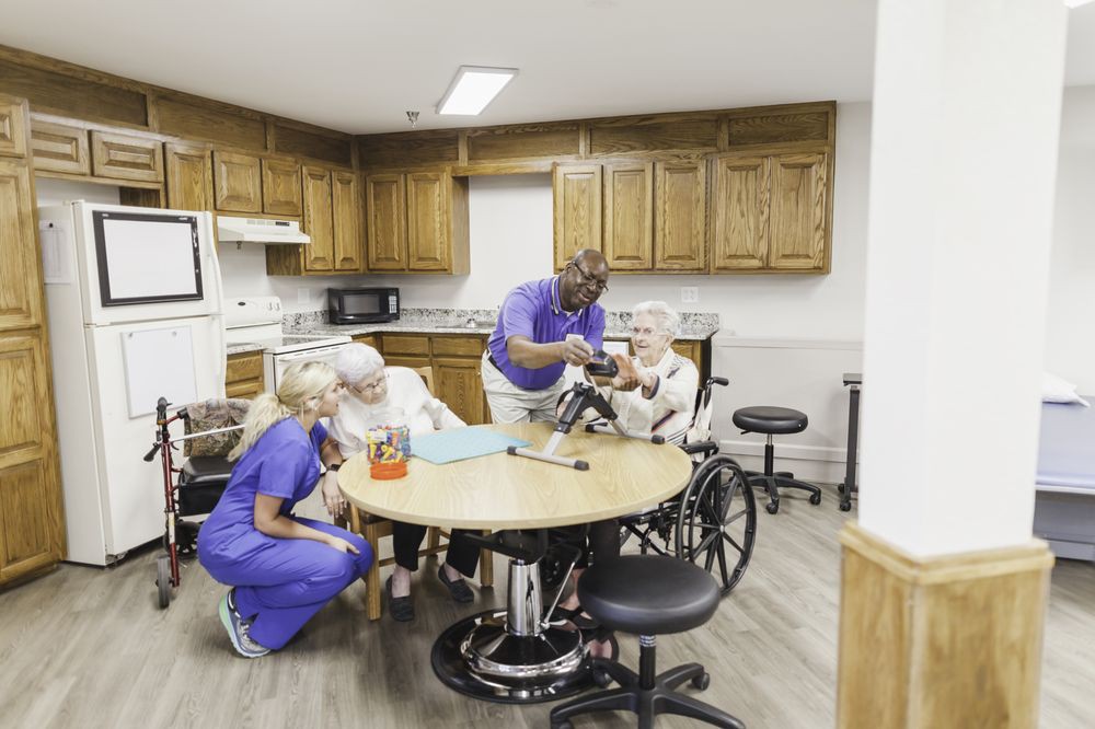 Healthcare professionals assist elderly individuals during a group activity in a nursing home.