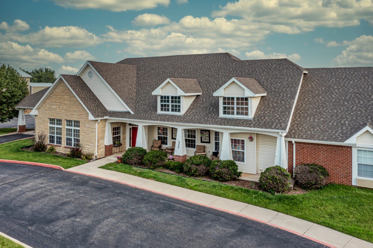 A charming suburban house with a manicured lawn and spacious driveway.