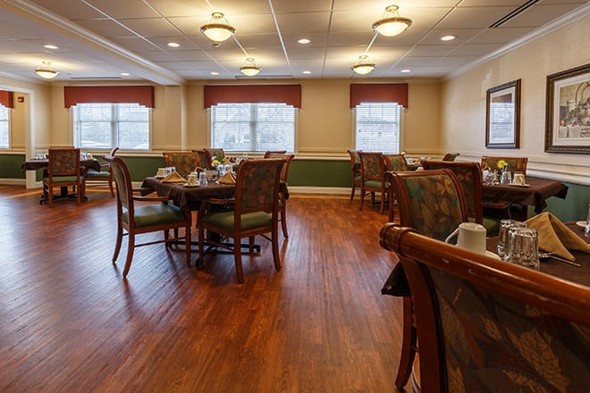 A well-lit dining room with neatly arranged tables and chairs, creating an inviting atmosphere.
