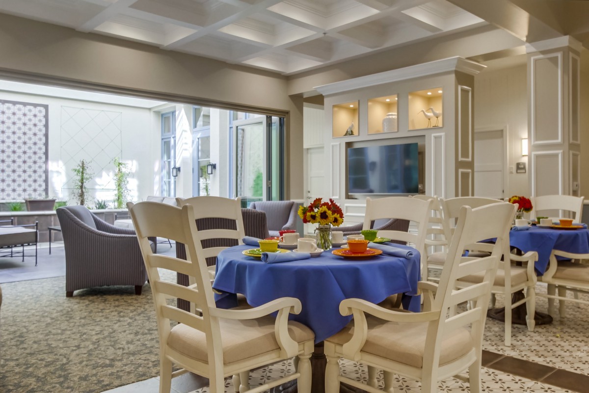 A well-decorated dining area with a blue tablecloth, adjacent to a cozy living room.