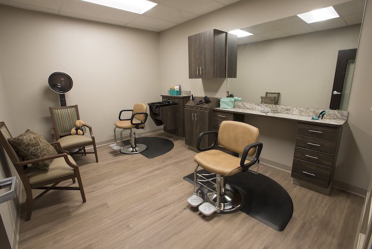 A modern hair salon interior with chairs, mirrors, and a sink.
