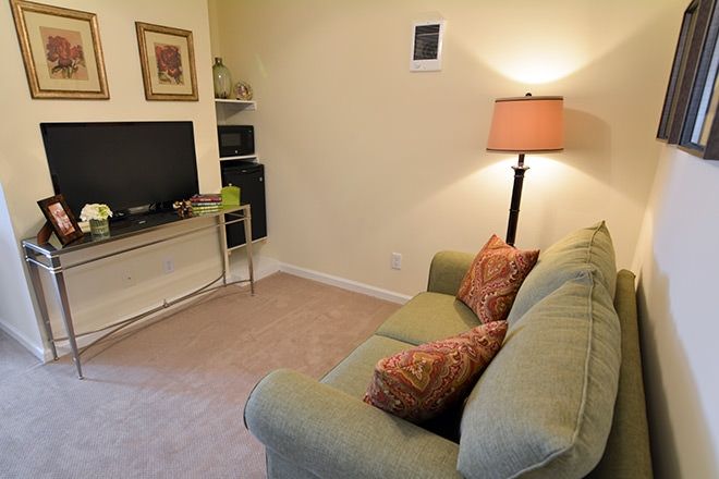 A cozy living room featuring a comfortable sofa, standing lamp, and television.