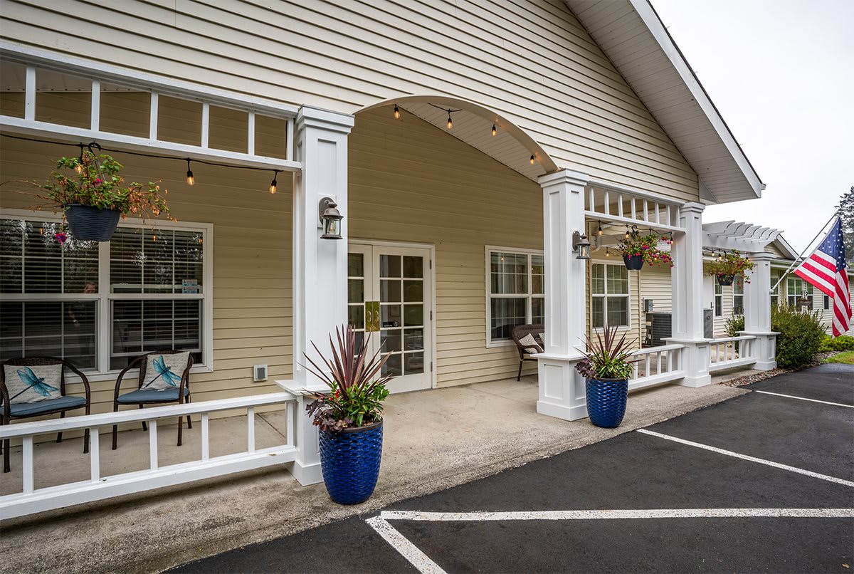 The exterior entrance of a building with decorative columns and potted plants.