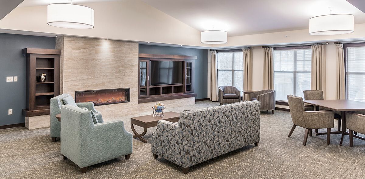 A cozy living room with sofas, a fireplace, and modern decor.