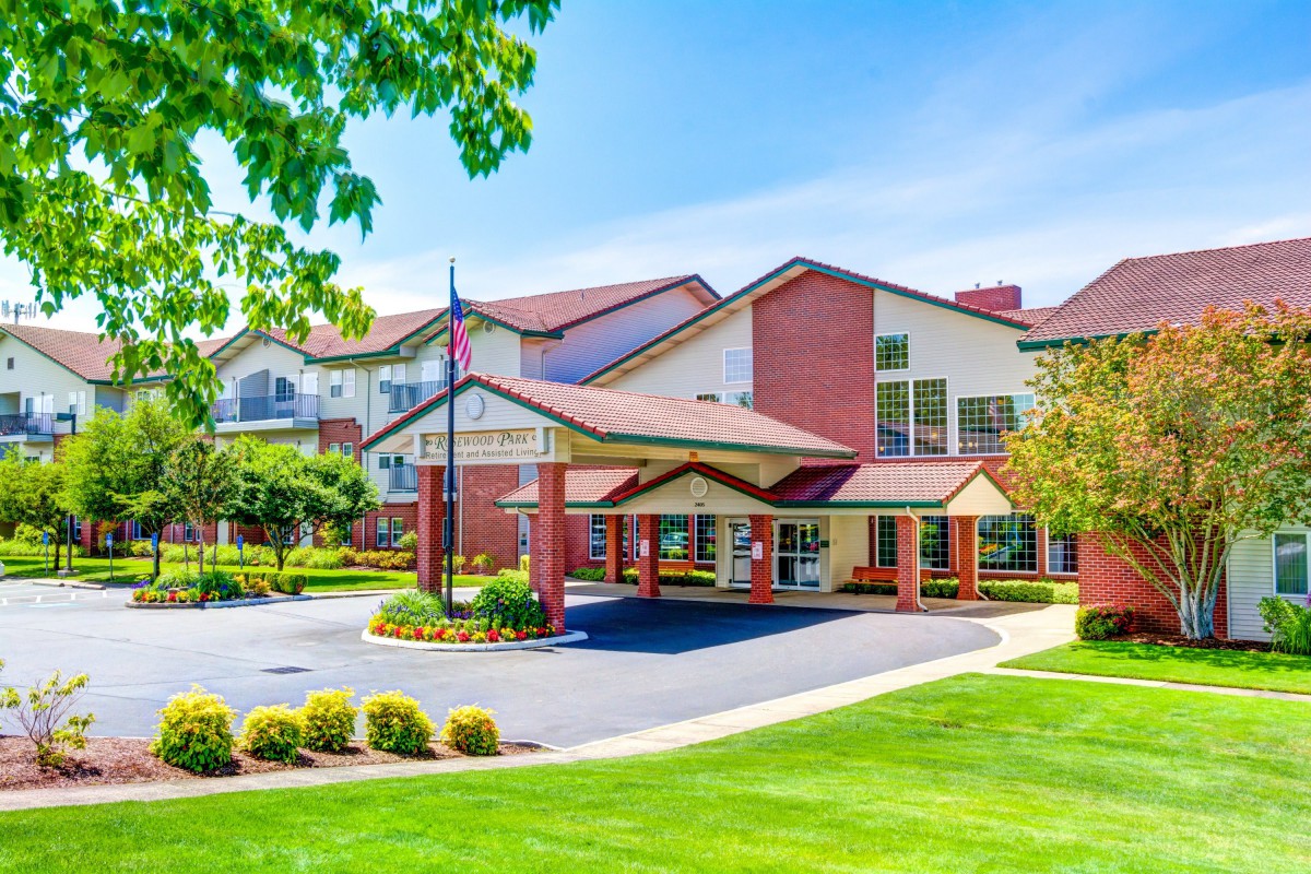 A well-maintained residential building with a lush green lawn and driveway.