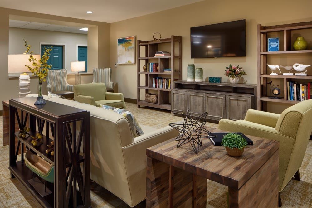 A modern living room with a cozy seating area, TV, and bookshelf.