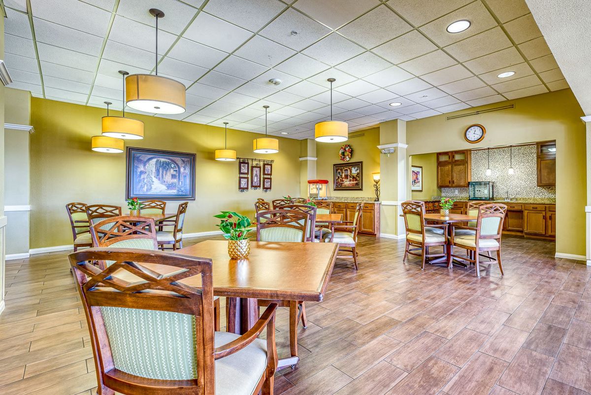 A well-lit dining area featuring wooden tables and chairs, with decorative elements on the walls.