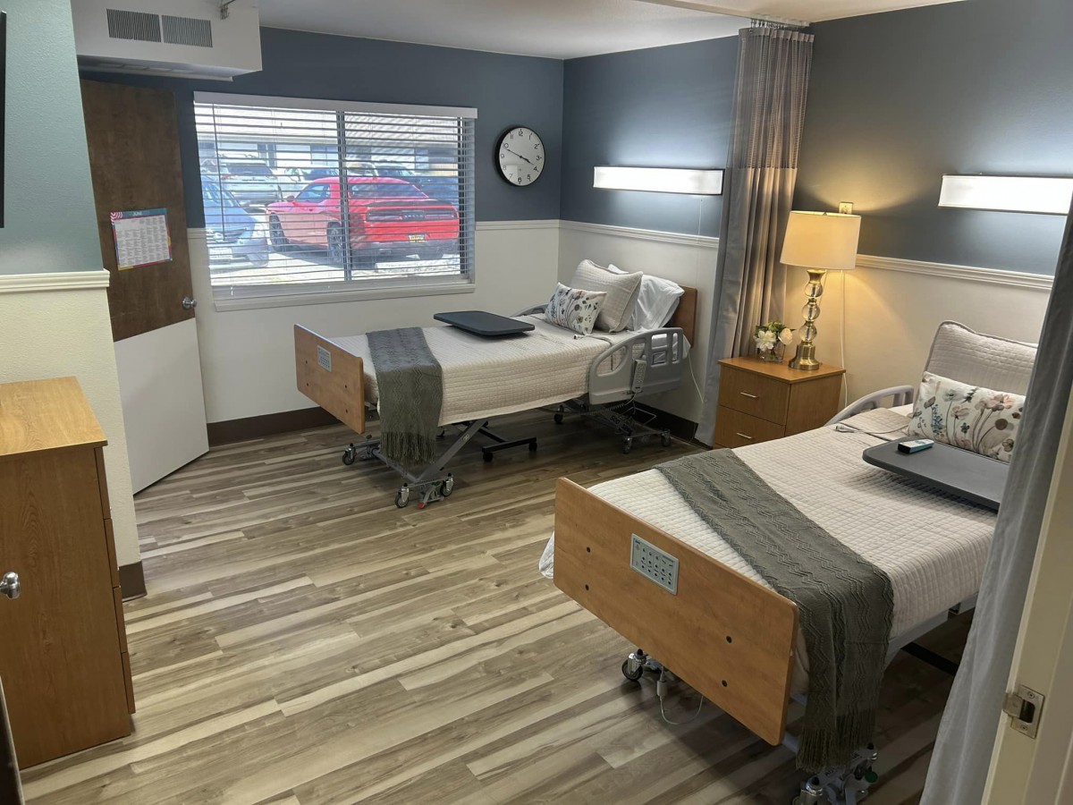 A hospital room with two patient beds and modern interior design.