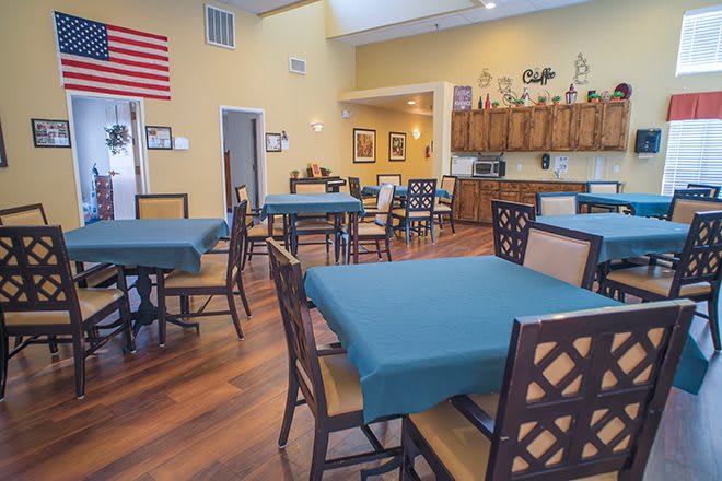A spacious and well-lit dining area with neatly arranged tables and chairs.