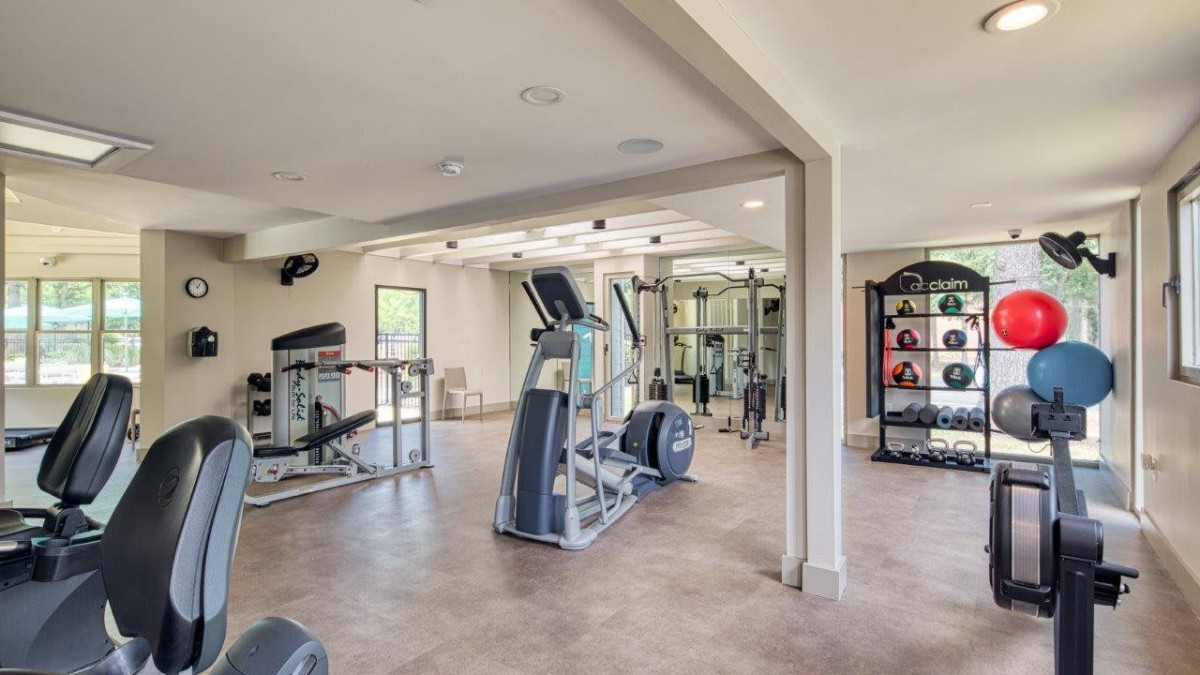 A spacious gym with modern exercise equipment and treadmills.