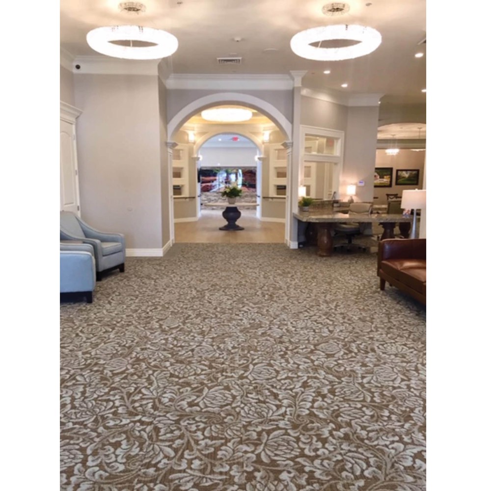 A spacious lobby area featuring elegant lighting, comfortable seating, and a decorative archway.
