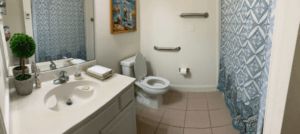 A clean bathroom with a toilet, sink, and towels neatly arranged.