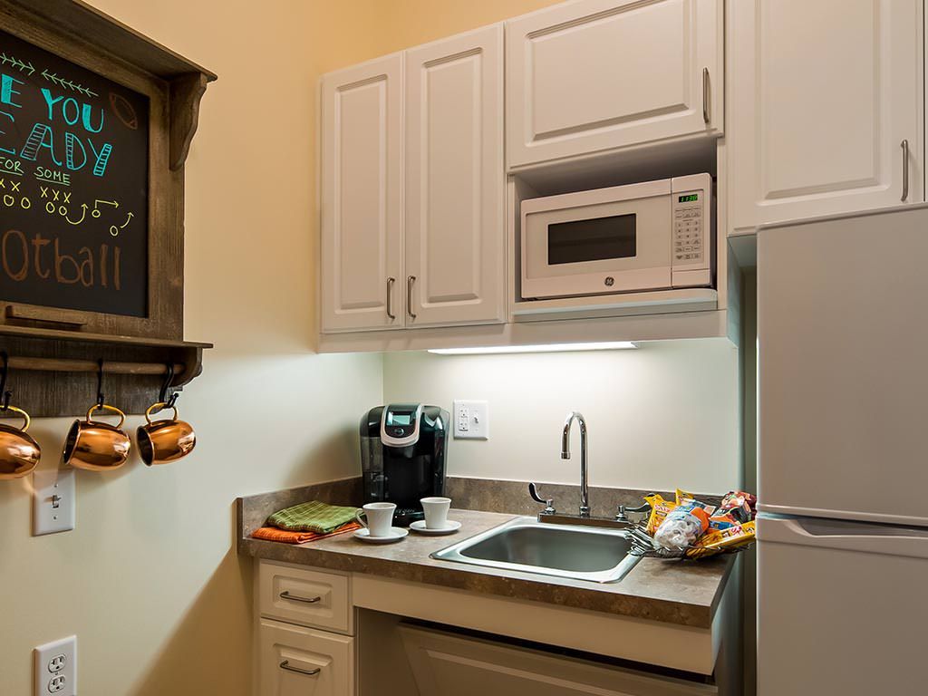 Compact kitchen area with a microwave, coffee maker, and sink.