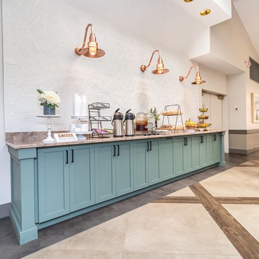 A modern buffet setup with stylish lighting and a sleek countertop.