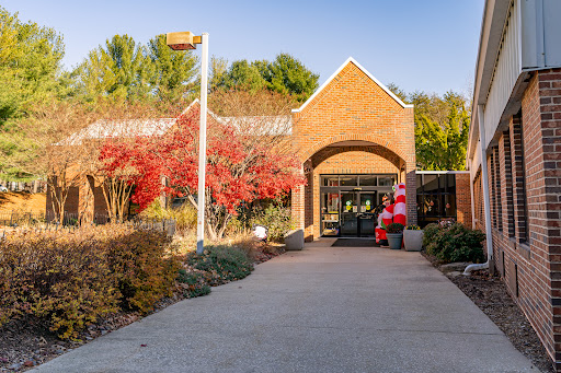 A festive entrance adorned with autumn foliage and a cheerful Santa Claus figure.